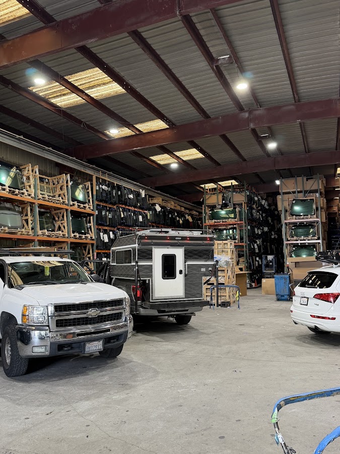 Racks of replacement windshields and a service truck inside the shop